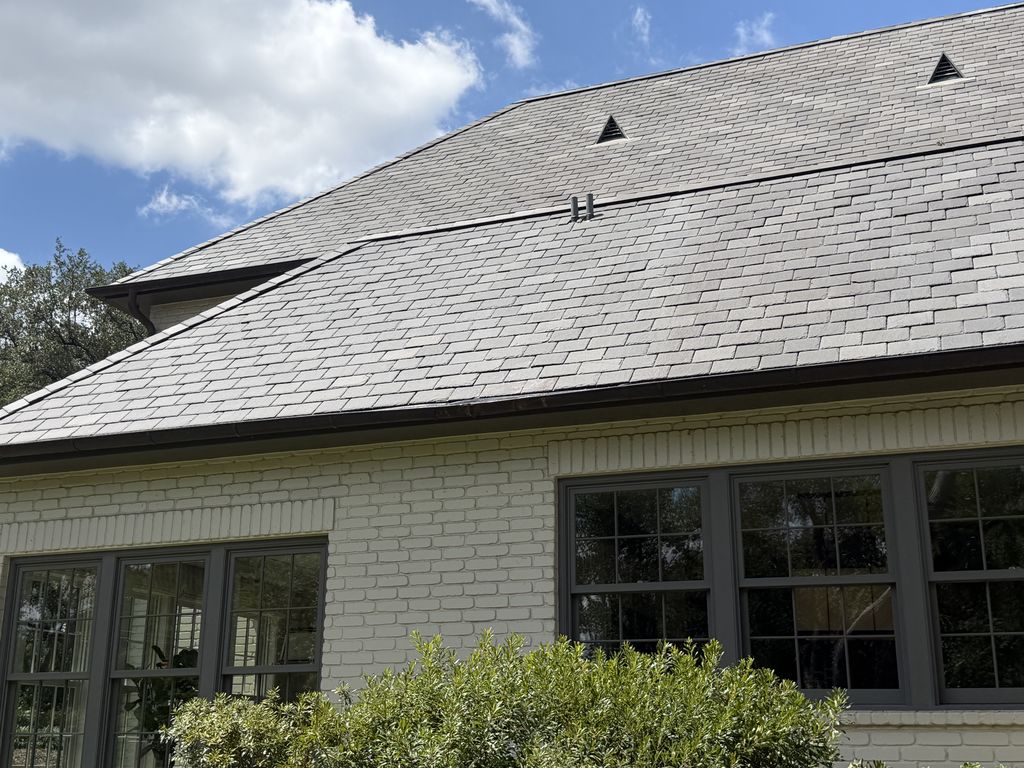 Completed synthetic slate roof replacement on a white painted brick home in San Antonio, Texas